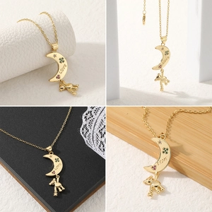 Detail of gold crescent moon pendant with LOVE engraving and hanging teddy bear charm