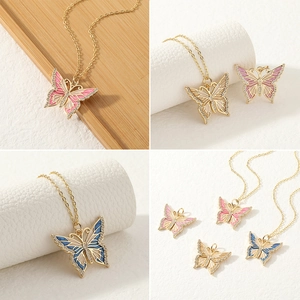 Detail van kleurrijke vlinderhangers met geëmailleerde vleugels en glanzende strass