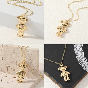 Detail view of a gold bear pendant with 'LOVE' engraving and colorful mini crystals