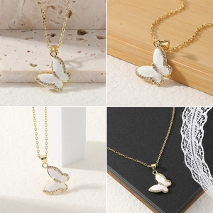Detailopname van de vlinder hanger ketting met wit emaille en fonkelende strass steentjes