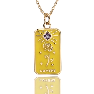 Detail of gold tarot pendant with yellow enamel, rose motif, and purple zircon