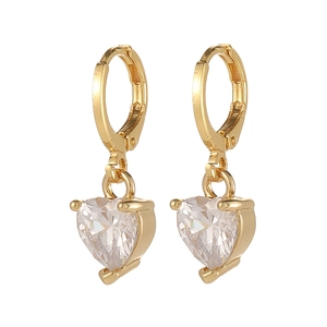 Détail de boucles d'oreilles cœur en zircone avec fermoir huggie doré brillant