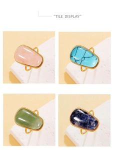 Detalle de cuatro anillos de piedra natural irregular con aros dorados de gran textura