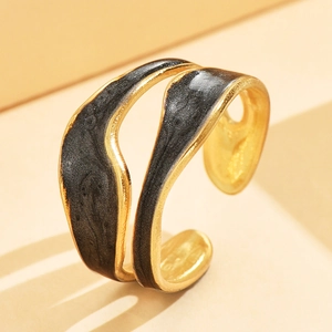 Elegante anillo vintage de acero dorado y esmalte negro con diseño geométrico irregular