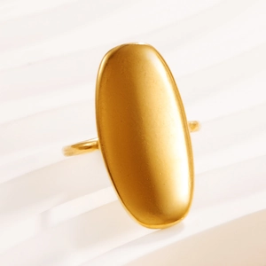 Anello geometrico ovale piatto in acciaio inossidabile dorato su tessuto bianco