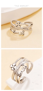 Detail of layered silver geometric ring with smile charm and lucky clover design
