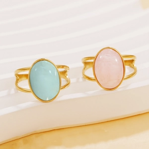Vintage geometric gold rings with blue and pink resin stones on minimalist display