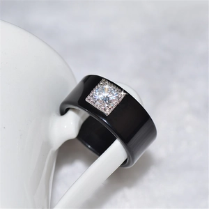 Anello nero lucido con incastonatura quadrata di cristallo su ceramica bianca