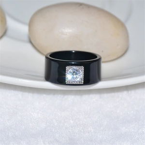 Macro di un anello nero lucido con castone quadrato e intarsio di diamante scintillante