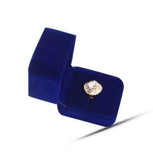 Detail view of sunflower shaped gold ring with circular stone in blue velvet box