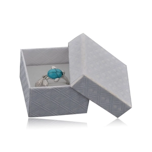 Detail of turquoise stone ring with silver leaf accents inside a blue textured gift box