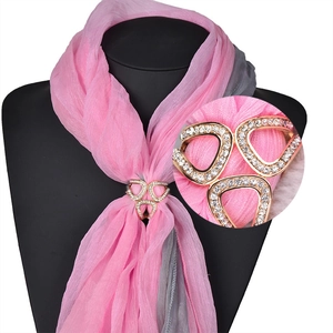 Détail de la boucle de foulard à trois anneaux dorés avec strass sur un foulard en soie