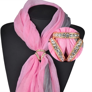 Détail d'une boucle de foulard à trois anneaux dorés avec strass étincelants