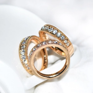 Gros plan de la boucle de foulard triple anneau or rose avec pavé de zircons étincelants