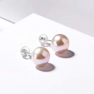 Dettaglio di orecchini con perle naturali rosa e marchio in argento sterling S925