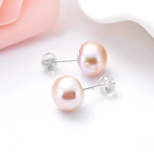 Vista macro degli orecchini a perno in argento S925 con perle rosa e chiusure in silicone