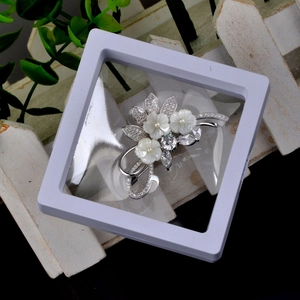 Detail of floral brooch with pearls and crystals in a transparent PE film display box
