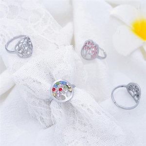 Detail der Lebensbaum-Ringe mit bunten Kristallen auf elegantem Spitzenhintergrund