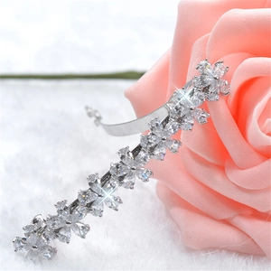 Pince à cheveux fleurie en argent avec zircons étincelants sur fond rose poudré