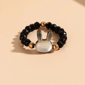 Detail of beaded rabbit ring with black faceted stones and mother of pearl rabbit charm
