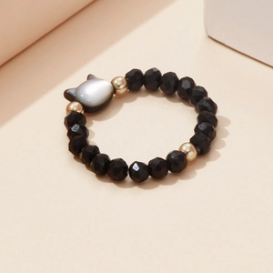 Detail of beaded cat ring with black faceted stones and a grey shell cat charm