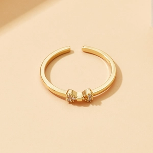 Dettaglio macro di anello a fiocco dorato con piccoli zirconi e fascia regolabile