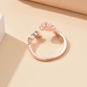 Gros plan détaillé d'une bague ajustable en or rose avec œil de chat et perles