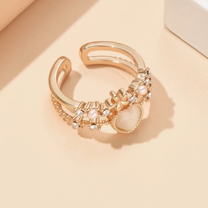 Vue macro détaillée d'une bague cœur dorée en œil de chat avec micro-perles et cristaux