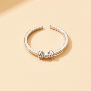 Dettaglio ravvicinato di un anello a fiocco argento con micro-pavé di zirconi