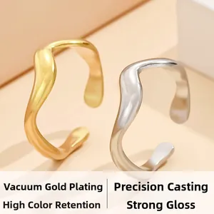 Detail von wellenförmigen offenen Ringen in Gold und Silber mit Vakuum-Beschichtung