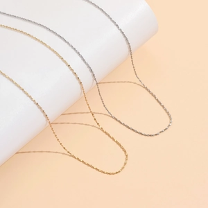 Minimalist 18K gold and silver star link necklaces for women displayed on a white stand