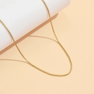 Collier chaîne box en acier inoxydable plaqué or 18K sur un support blanc minimaliste