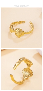 Detailaufnahme eines goldenen Muschelrings mit Wellentextur auf der Ringschiene