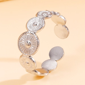 Vintage silver sunburst engraved open ring in brushed stainless steel on orange backdrop