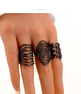 Driedelige matzwarte gotische ringenset met spiraal- en gaaspatronen op handmodel
