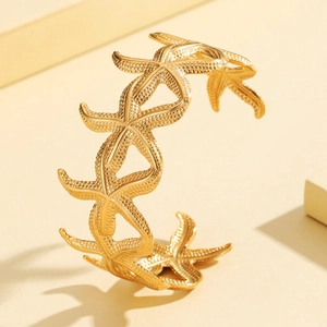 Elegant gold starfish open bangle featuring textured sea stars for beach vacation style