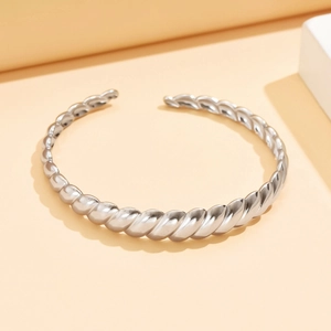 Polished silver twisted rope open cuff bracelet in stainless steel on minimalist display