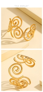 Primer plano de brazalete abierto dorado con patrones de espirales continuas