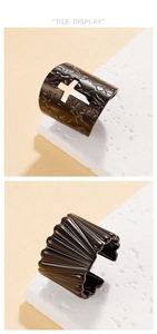 Close-up of black punk rings with hollow cross patterns and irregular lava textures