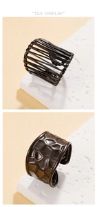 Close-up of punk style wide hollow cross and honeycomb textured black stainless steel rings