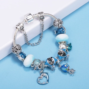 Silver ocean themed beaded bracelet with turtle and heart charms on blue background