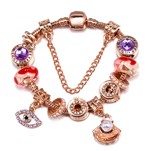 Rose gold sunflower charm bracelet with purple crystals and shell pearls on white background