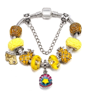 Detail of silver snake chain bracelet featuring yellow enamel charms and starfish pendant