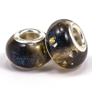 Detailed view of two dark resin galaxy beads with gold foil for DIY jewelry making