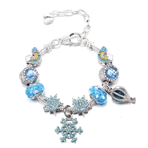 Dettaglio del bracciale a maglia snake regolabile con perle in vetro blu e ciondoli neve