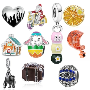 Macro shot of assorted silver charms with enamel and zirconia insets on white background