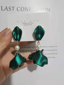 Detail of 925 silver post earrings with emerald green leaf drop and pearl bead
