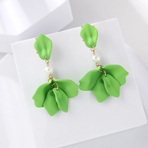 Matte green leaf drop earrings with white pearl detail on minimalist white stand
