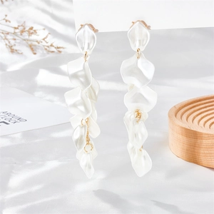 Detail of pearlescent white resin petals and gold alloy cascading tassel earrings