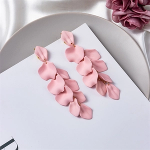 Detail view of long tiered pink flower petal tassel earrings on a satin silk background